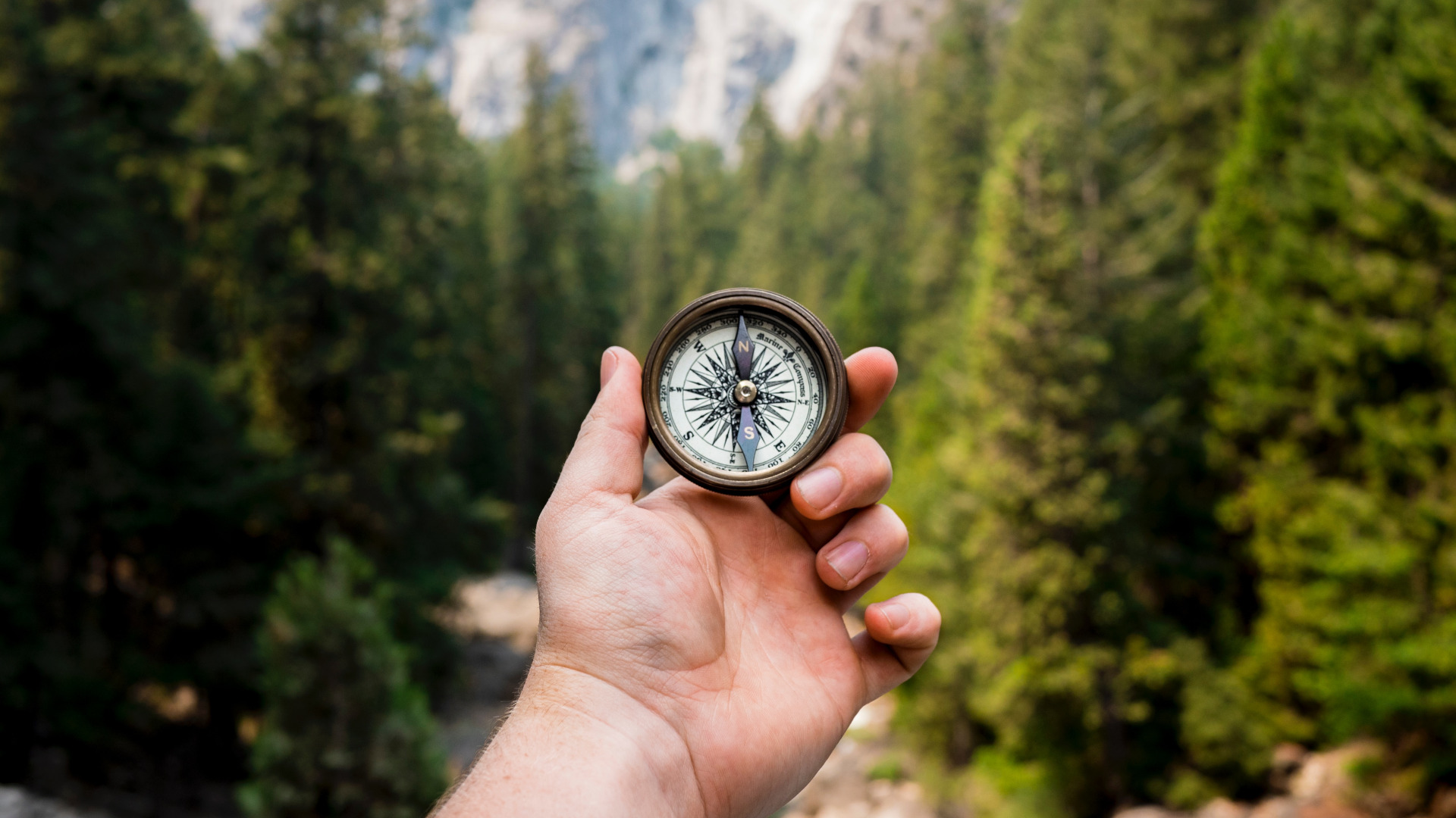 Hand holding compass for direction